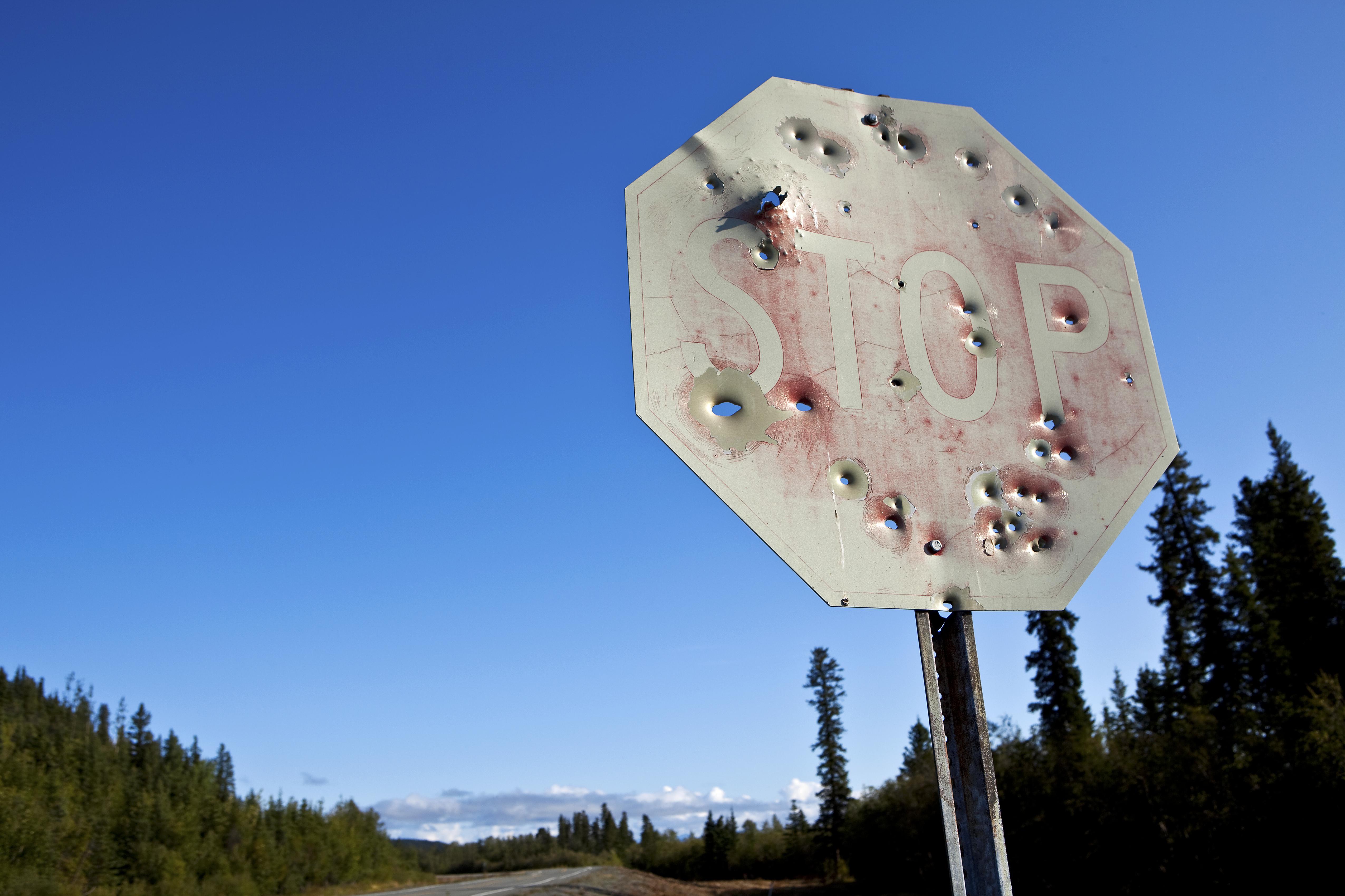 Stop sign riddled with bullet holes