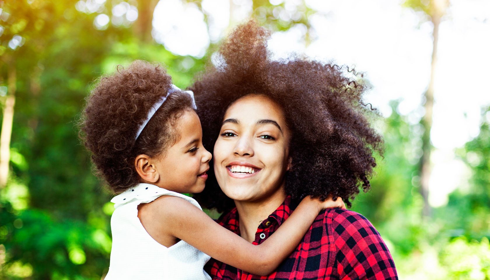 Mother and daughter hugging outdoors