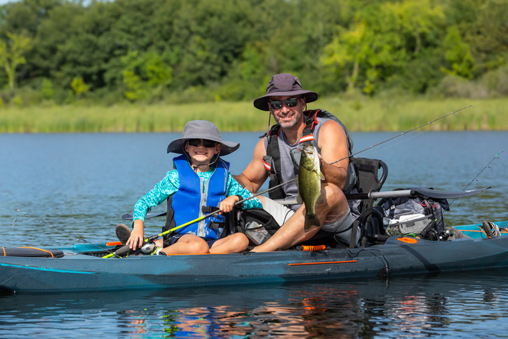 Young Boy & Dad Holding Fish Caught From Kayak