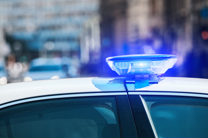 Police car with blue lights in traffic urban environment.