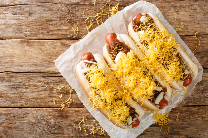American Cincinnati Chili hot dog closeup in the paper. Horizontal top view